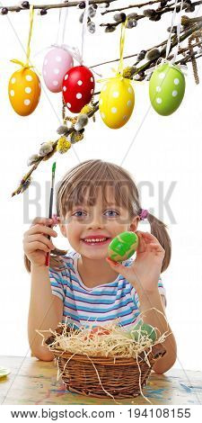 a happy little girl painting easter eggs - white background