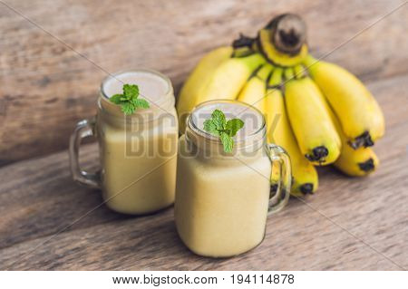 Banana Smoothies And Bananas On An Old Wooden Background