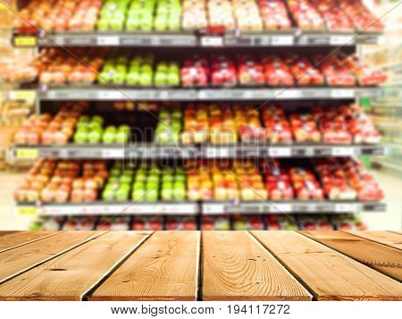 Abstract blur and defocused fruit and vegetables department for background and empty wooden table space platform for present product.
