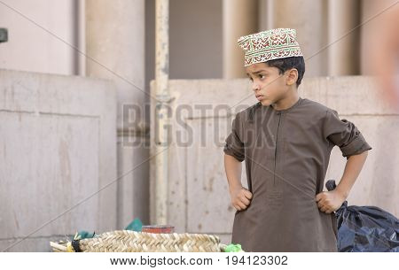 Nizwa Oman June 23rd 2017: omani boy in traditional clothing at a market