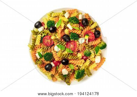 A photo of a plate of pasta salad with basil leaves, shot from above, isolated on a white background