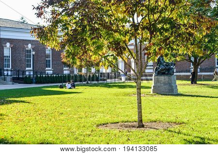Charlottesville USA - October 20 2013: Autumn on lawn of University of Virginia with Old Cabell Hall Homer statue and students sitting on grass