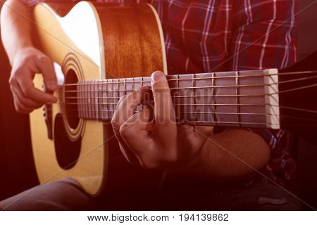 Practicing in playing guitar. Handsome young men playing guitar.