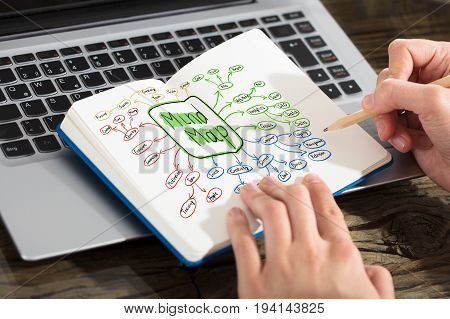 A Businesswoman Drawing Mind Map Concept With Pencil On Notebook Over The Laptop
