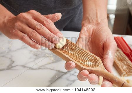 Homemade Gnocchis being prepared by rolling on a Gnocchi tool