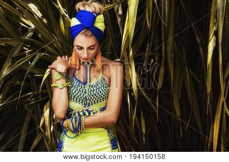 Beautiful girl in turban posing in the garden yelow dress