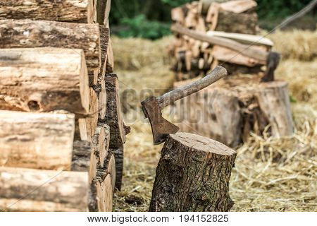 A Deck Of Stacked Logs And An Axe
