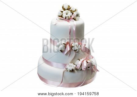 White three-tiered cake with cotton and pink ribbon isolated on white background