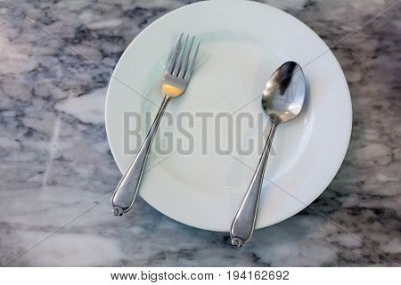 Set Spoon on white plate at kitchen room.