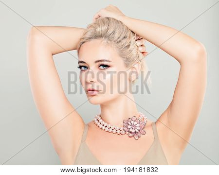 Beautiful Glamorous Blonde Woman Fashion Model with Pink Flower Necklaces and Blonde Hairstyle