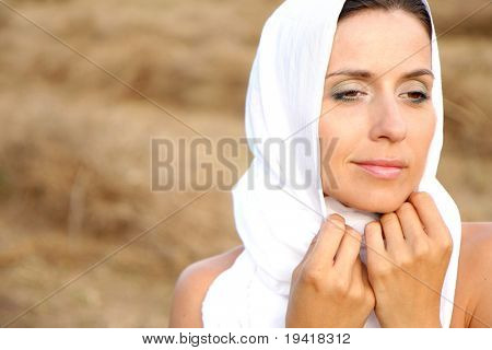 Donna di purezza sul campo con sciarpa bianca e viso pulito