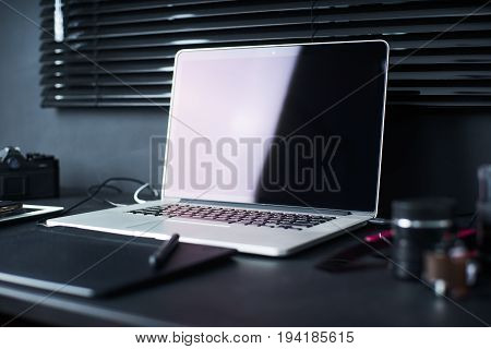 Work space on black table of a photographer or designer with laptop retro camera Stylish home studio concept of hipster . Seleted focus.