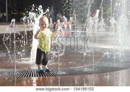 Funny Toddler In Fountain. Cute Baby Boy Having Fun And Plaing In Fountain.