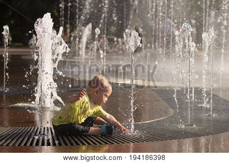 Funny Baby Boy Splashing In Fountain. Cute Toddler Playing With Water Stream