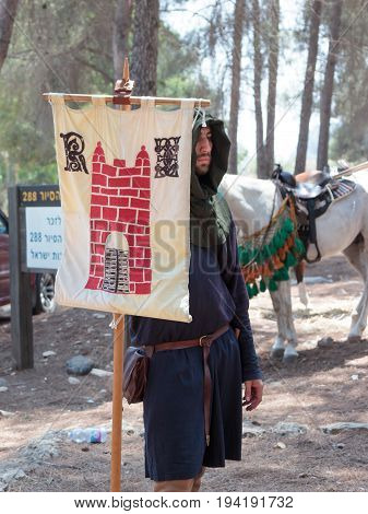Tiberias Israel July 01 2017 : Participant in the reconstruction of Horns of Hattin battle in 1187 stand with the flag of the King of Jerusalem in the camp before the campaign near TIberias Israel