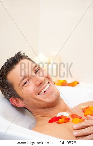 Sourire mignon homme ayant un matin joyeux dans la baignoire