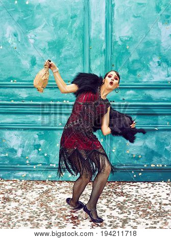 The studio shot of female dancer dancing at retro dress. Concept of cabaret, luxury party and jazz