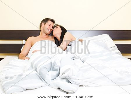 Landschaftlich im Schlafzimmer der paar junges Liebespaar im Bett aussehende Eachother romantische beim Cuddl liegen