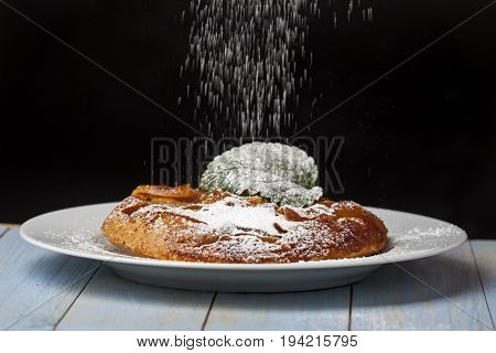 tarte tatin with icing suger on black background