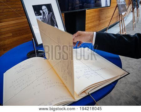 STRASBOURG FRANCE - JUL 1 2017: The messages in diverse languages of high ranked officials on the book of condolences next to a portrait of late former German Chancellor Helmut Kohl at European Parliament. Kohl who was Christ democrat or CDU party member
