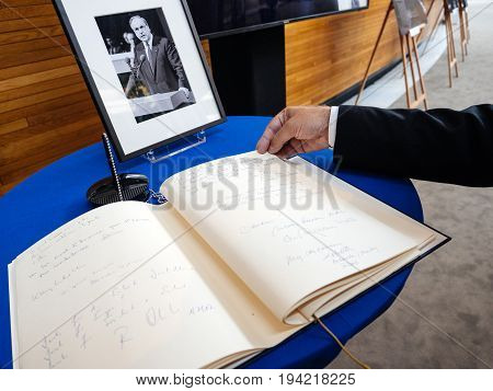 STRASBOURG FRANCE - JUL 1 2017: The messages in diverse languages of high ranked officials on the book of condolences next to a portrait of late former German Chancellor Helmut Kohl at European Parliament. Kohl who was Christ democrat or CDU party member