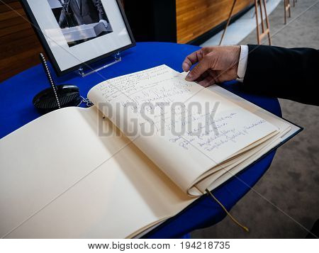 STRASBOURG FRANCE - JUL 1 2017: The messages in diverse languages of high ranked officials on the book of condolences next to a portrait of late former German Chancellor Helmut Kohl at European Parliament. Kohl who was Christ democrat or CDU party member