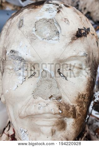 Decommunization in Ukraine. Damaged bust of Lenin in the garbage dump. Close-up.