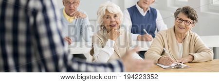 Senior women looking flirtatiously at male teacher during lecture