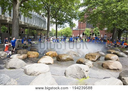 CAMBRIDGE MA, USA - JULY 1 2017: Fountain at Harvard University. People sit around the fountain in Harvard