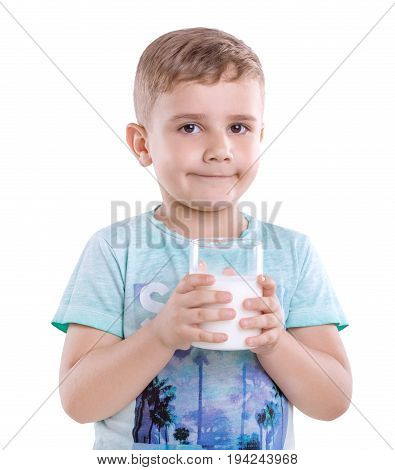 A nice little child in a blue t-shirt with a cup of delicious milk. Healthful and organic food and drings. A cute kid is holding a full glass of fresh and organic milk isolated on white background.