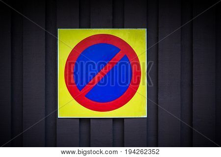 No parking sign. Prohibition symbol. Sign indicating warning and forbidden. Grunge shabby paper sticker isolated on dark wooden background.
