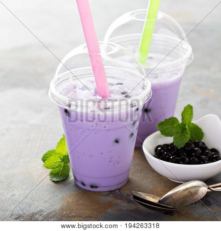 Berry bubble tea in plastic cups with lids and straws