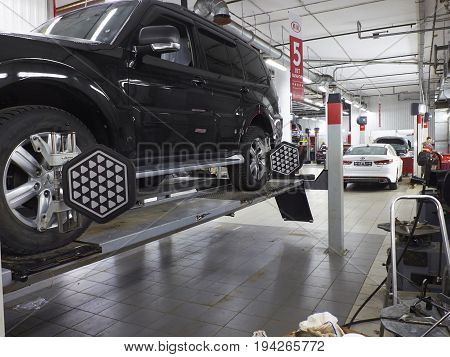MOSCOW, MAR,02, 2017: Car automobile wheel alignment maintenance works repair at automotive service center workshop. Technical maintenance wheel alignment correction fixation MOT. Car maintenance