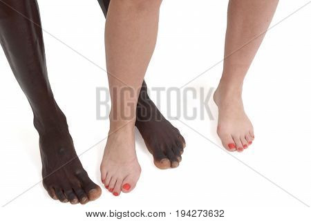 Feet and legs of an interracial couple on white