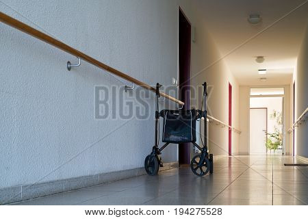 MAGDEBURG, GERMANY - JUNE 12, 2017: long dark hallway and rollator in a dreary nursing home for old people in Magdeburg.
