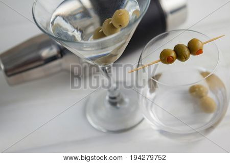 High angle view of vodka martini with cocktail shaker on wooden table