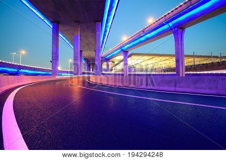 Empty Road Floor With City Viaduct Bridge Of Neon Lights Night