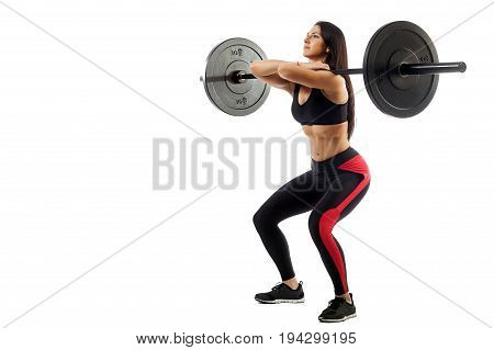 Young athletic brunette woman doing squat with a barbell loki in front of him position of a half-squat on a white isolated background