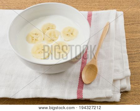 Bowl of Homemade Yoghurt Topping with Ripe Banana Nutritionally Rich in Protein Calcium Riboflavin Vitamin B6 and Vitamin B12.