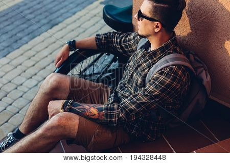 Young Man In Sunglasses Rests On Steps Next To Bicycle Holiday Activity Resting Concept