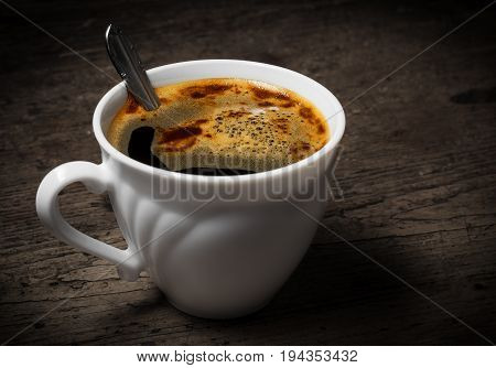 a cup of coffee on an old wooden table - vintade style