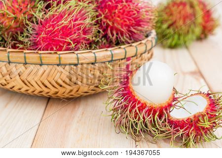 fresh tropical rambutan fruits over basket with knife on wood background fruit in Thailand