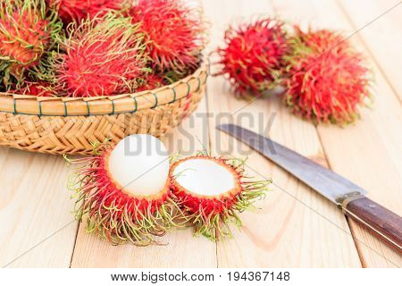 fresh tropical rambutan fruits over basket with knife on wood background fruit in Thailand