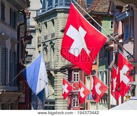 Ancient street Augustinergasse in Zurich decorated with swiss flags