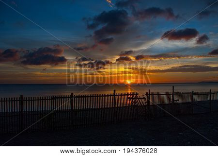 Beautiful Sunset On The Beach.the Silhouette Of The Fence. The Setting Sun Over The Horizon. Pandan,