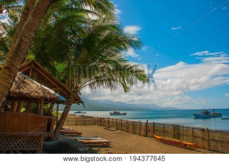 Sunbeds And Palm Trees On The Beach Against The Sea. Pandan, Panay Island, Philippines.