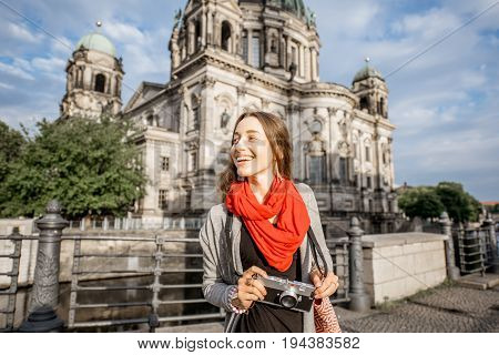 Young woman tourist with photo camera enjoying traveling in Berlin city walking near the famous cathedral