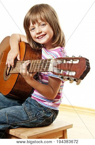 a little girl is playing a guitar