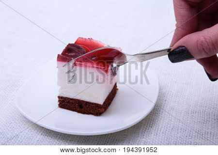 Slice of handmade cherry pie on a plate in white background.
