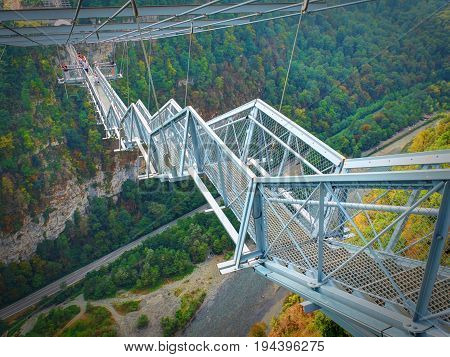 Metal bridge stair staircase above river. Metal architecture. Bangee jumping SkyPark Sochi adrenaline places for tourists. Best sightseeing holiday vacation tours.